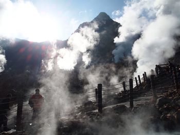 Smoke emitting from volcanic mountain against sky