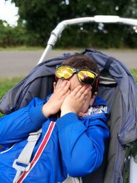 Boy sitting on baby carriage