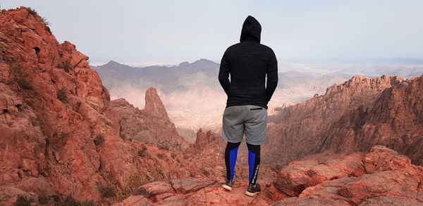 Rear view of man walking on rock