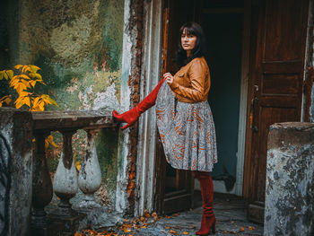 Young woman standing against wall