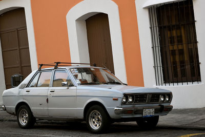 Vintage car parked on street against building