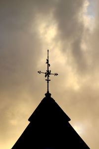 Low angle view of weather vane against sky