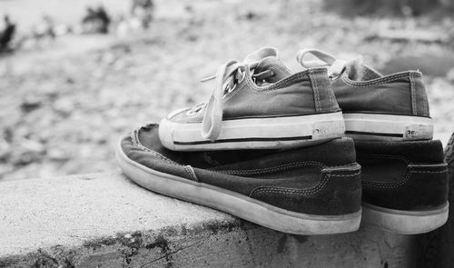 Close-up of shoes on beach