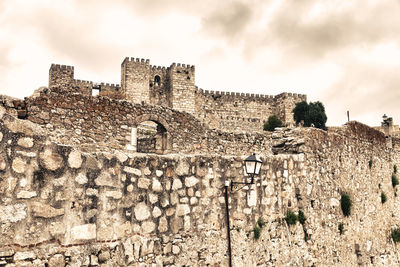 Low angle view of old building against cloudy sky