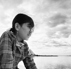 Portrait of woman looking away against sky