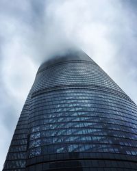 Low angle view of modern building against cloudy sky