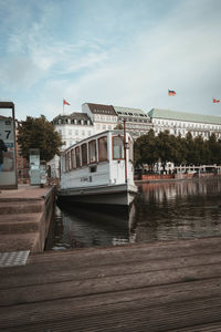 Boat moored by river against sky