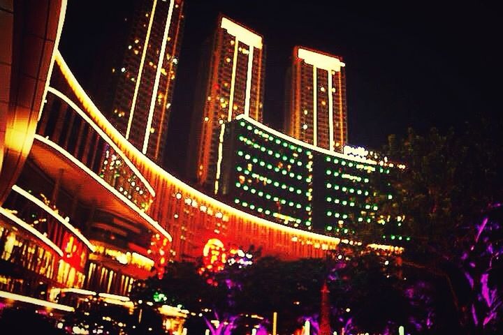 LOW ANGLE VIEW OF ILLUMINATED BUILDING AT NIGHT