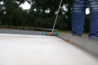 Midsection of person playing miniature golf