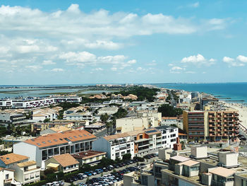 High angle view of townscape by sea against sky