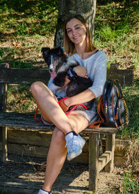 Portrait of young woman sitting on wooden bench