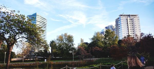 Trees and buildings against sky in city