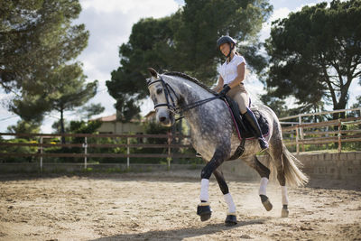 Woman riding horse in ranch