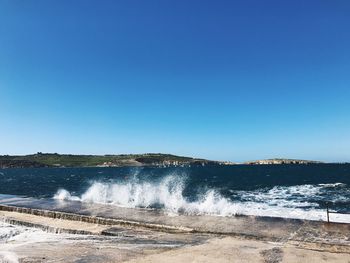 Scenic view of sea against clear blue sky