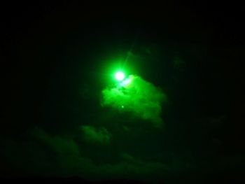 Low angle view of illuminated moon in sky at night