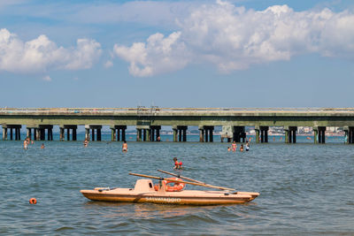 People in sea against sky