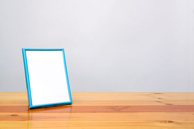 Wooden table against blue wall at home