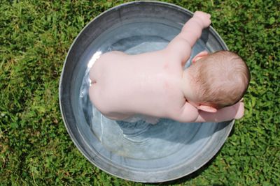 High angle view of baby hand on grass