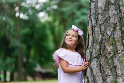 Little girl playing in the woods summer