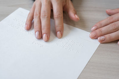 Midsection of person reading book on table