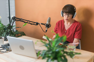 Side view of woman using mobile phone on table