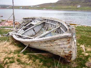 Abandoned boat moored on shore