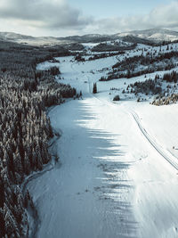 Scenic view of snow covered land against sky