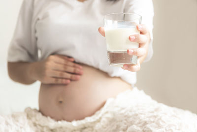 Midsection of woman drinking glass