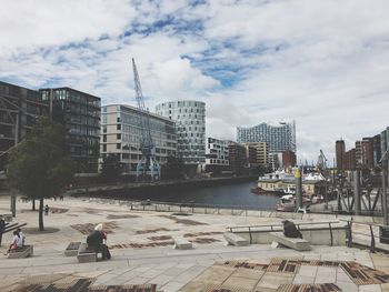 View of cityscape against cloudy sky