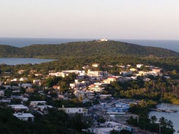 High angle view of townscape by sea against sky