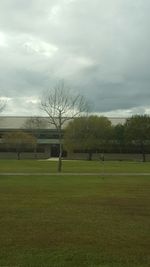 Scenic view of grassy field against cloudy sky