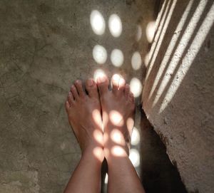 Low section of woman standing on tiled floor