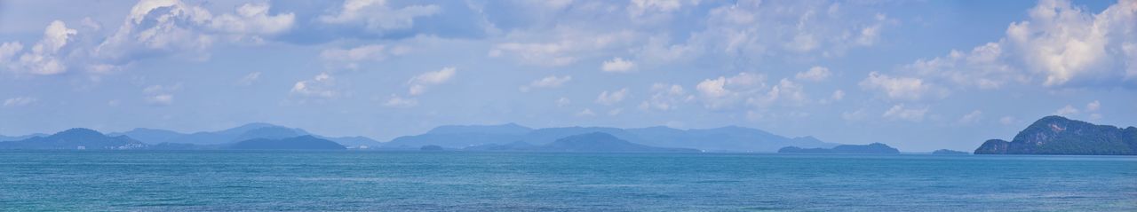 Panoramic view of sea and mountains against sky