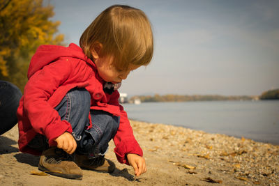 Side view of cute boy sitting outdoors