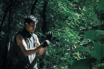 Young man using mobile phone in forest