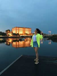 Full length of woman standing on illuminated city at night