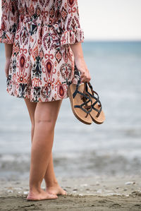 Low section of woman standing on beach