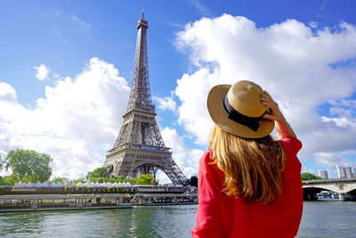 Holidays in paris back view of beautiful fashion girl enjoying view of eiffel tower in paris, france