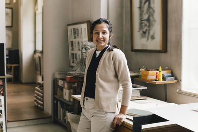 Portrait of smiling businesswoman standing in workplace