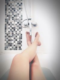 Low section of woman holding hands on tiled floor