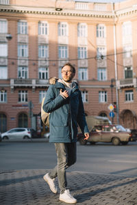 Photo of attractive adult male in blue jacket. pleasant man with beard and glasses goes to work 