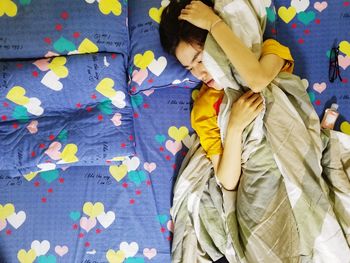 High angle view of woman resting on bed