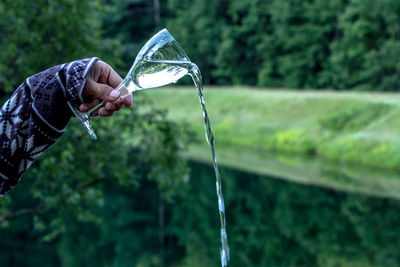 Cropped image of hand pouring water