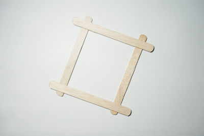 High angle view of cross on wood against white background