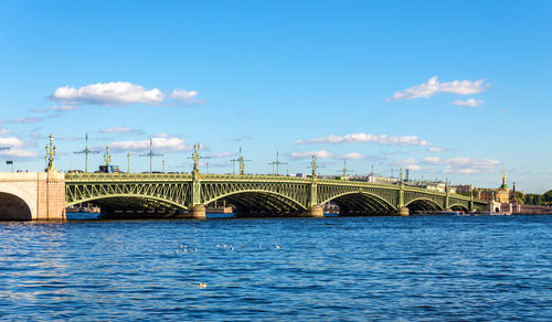 Arch bridge over river against sky in city