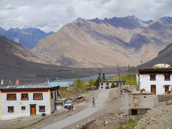 Buddhist monasteries by himalayas against cloudy sky