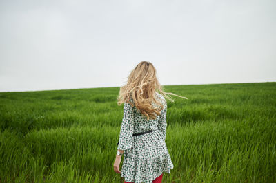 Woman wearing hat on field against sky