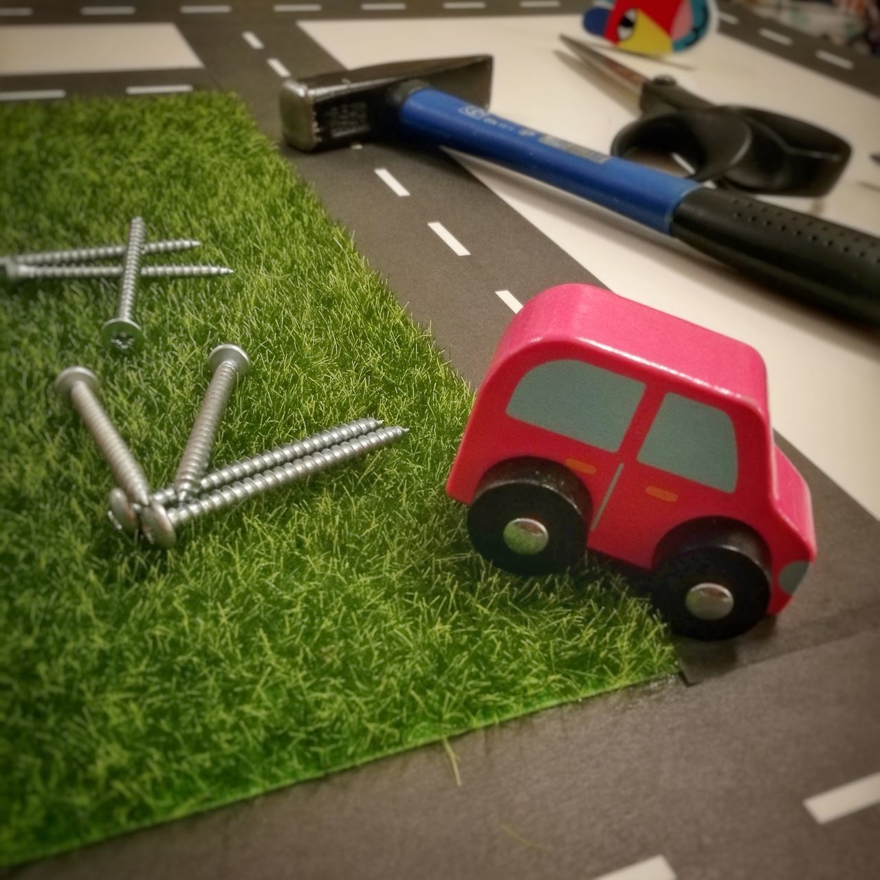 HIGH ANGLE VIEW OF TOY CAR ON GREEN TABLE