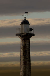 Low angle view of tower and building against sky during sunset