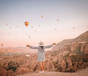 Full length of person standing on rock against sky